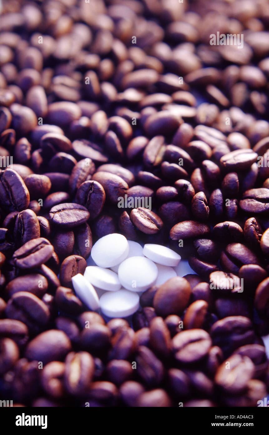 Kaffeebohnen mit einigen weißen Tabletten im unteren Teil des Frame-Konzept oder Hintergrund Stockfoto