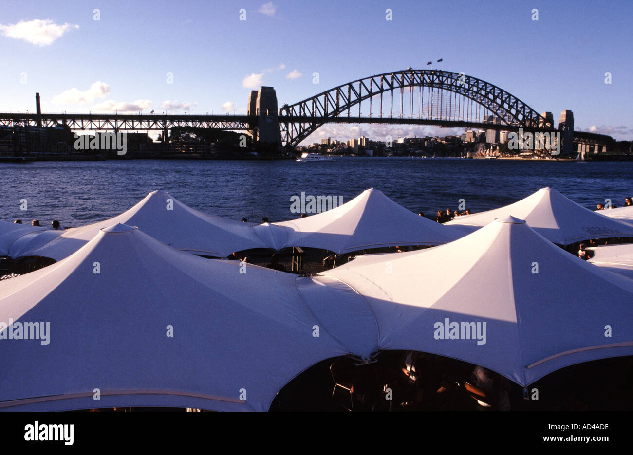 Sydney Harbour Bridge in der Nähe von Sydney Opera House mit Café Sonnenschirme an der Basis des Bildes Stockfoto
