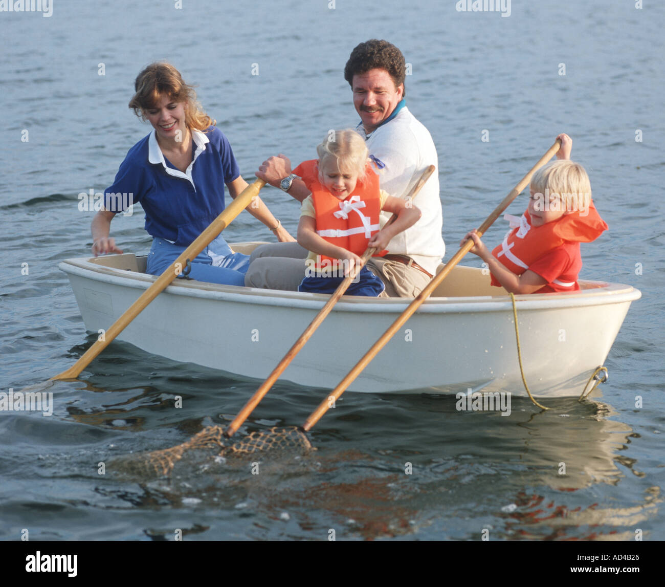 vierköpfige Familie im Ruderboot mit Netzstrümpfen Stockfoto