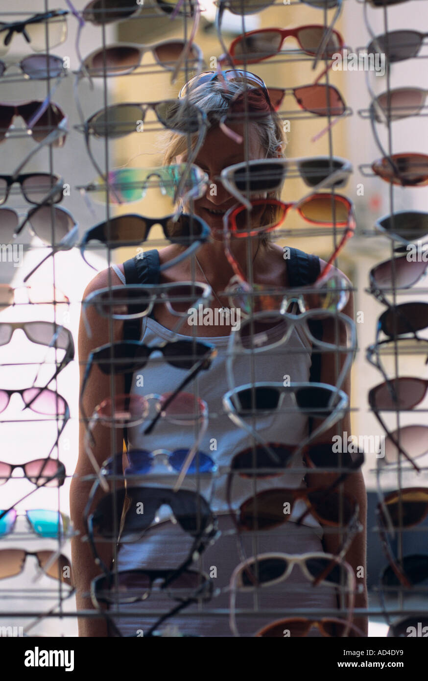 Sonnenbrille auf Verkauf in einer spanischen Stadt mit lady anzeigen Hinter einem Rack Stockfoto