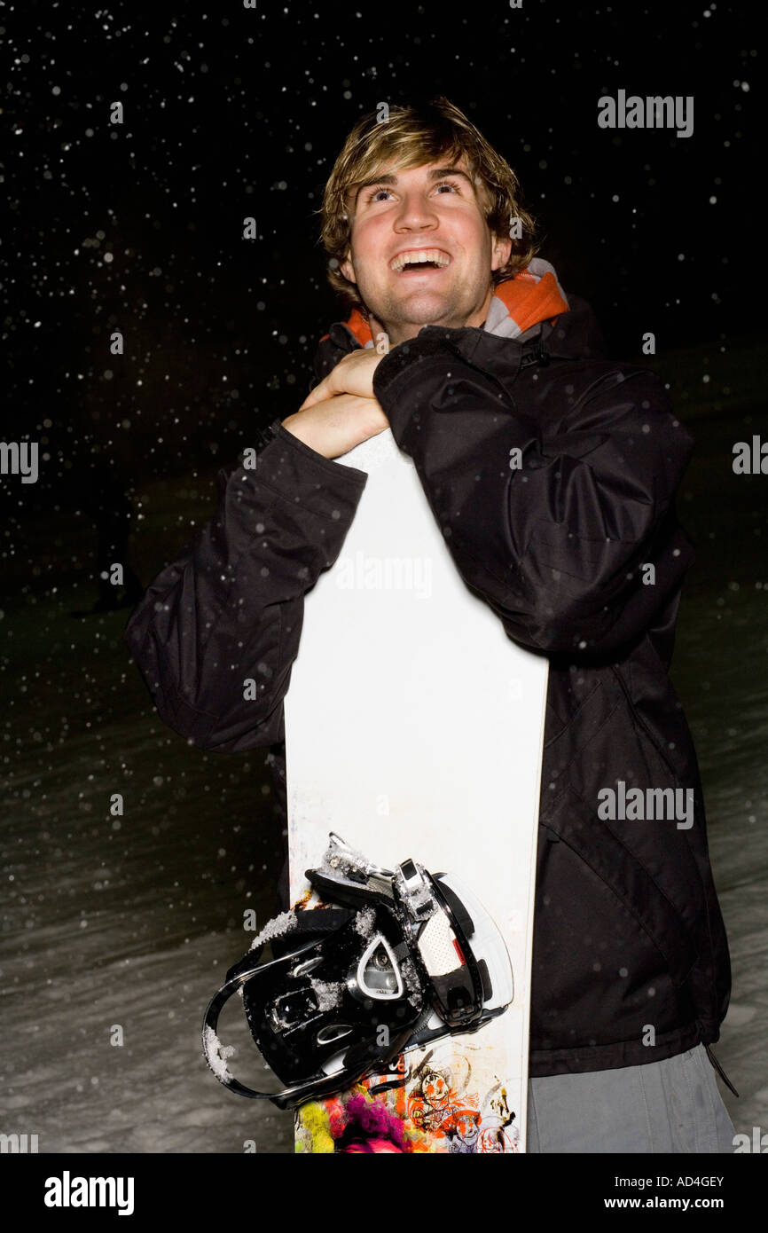 Junger Mann stehend auf einer Skipiste mit einem snowboard Stockfoto