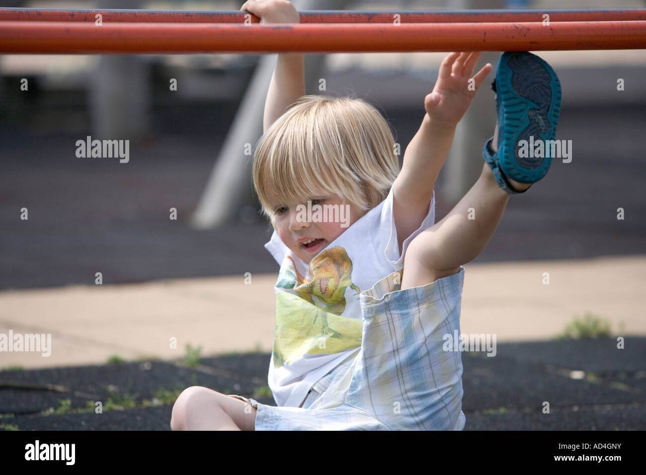 Junge fällt von einer Kletterstange auf dem Spielplatz Stockfoto