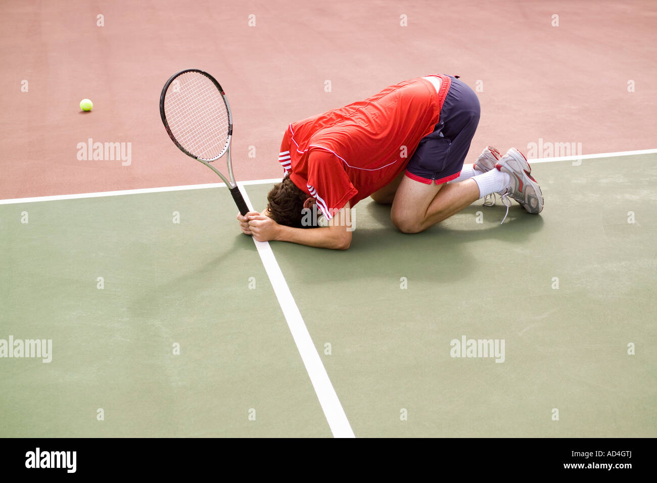 Ein Tennisspieler hocken auf dem Boden in der Niederlage Stockfoto