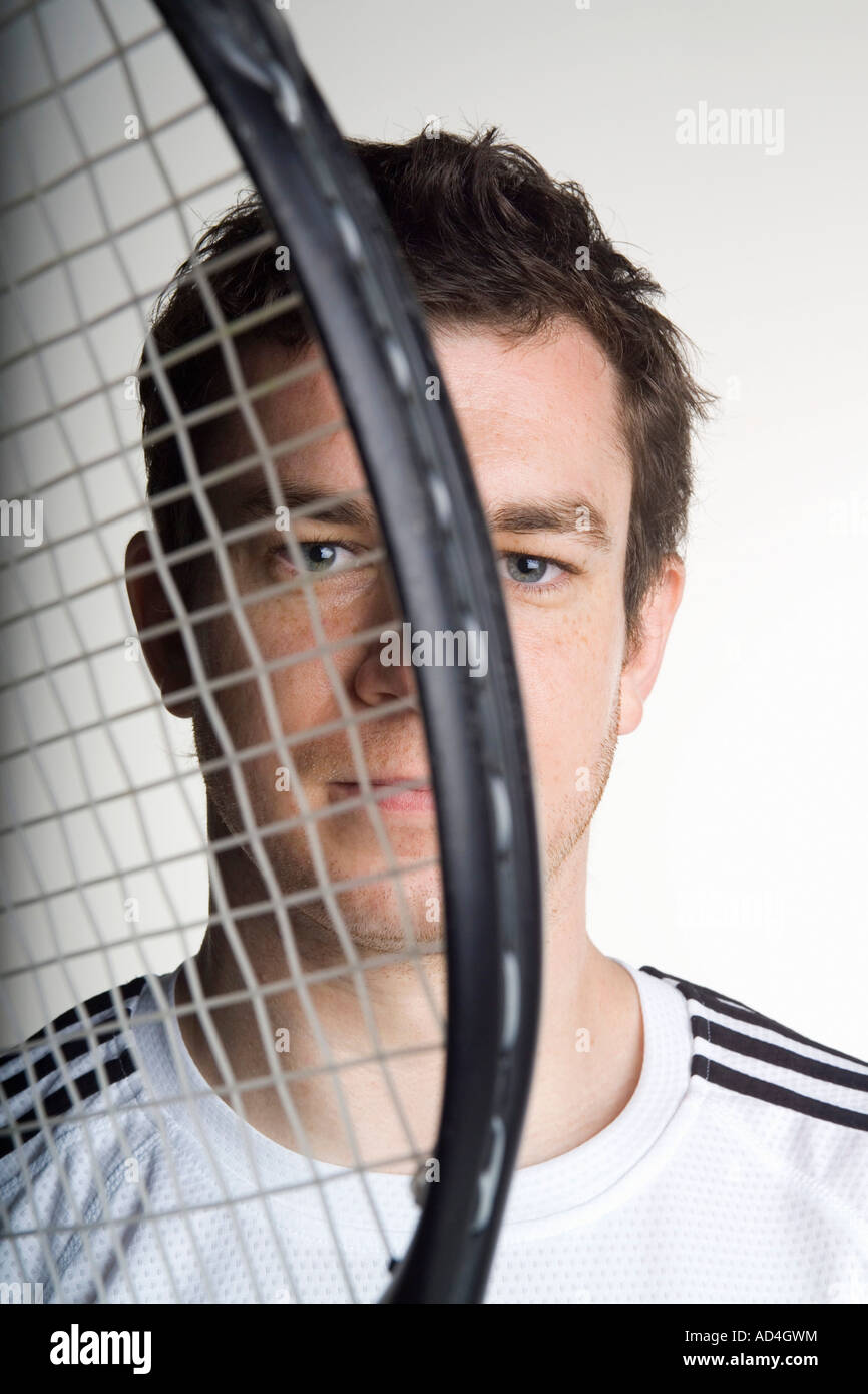 Porträt von ein Tennisspieler einen Tennisschläger vors Gesicht halten Stockfoto