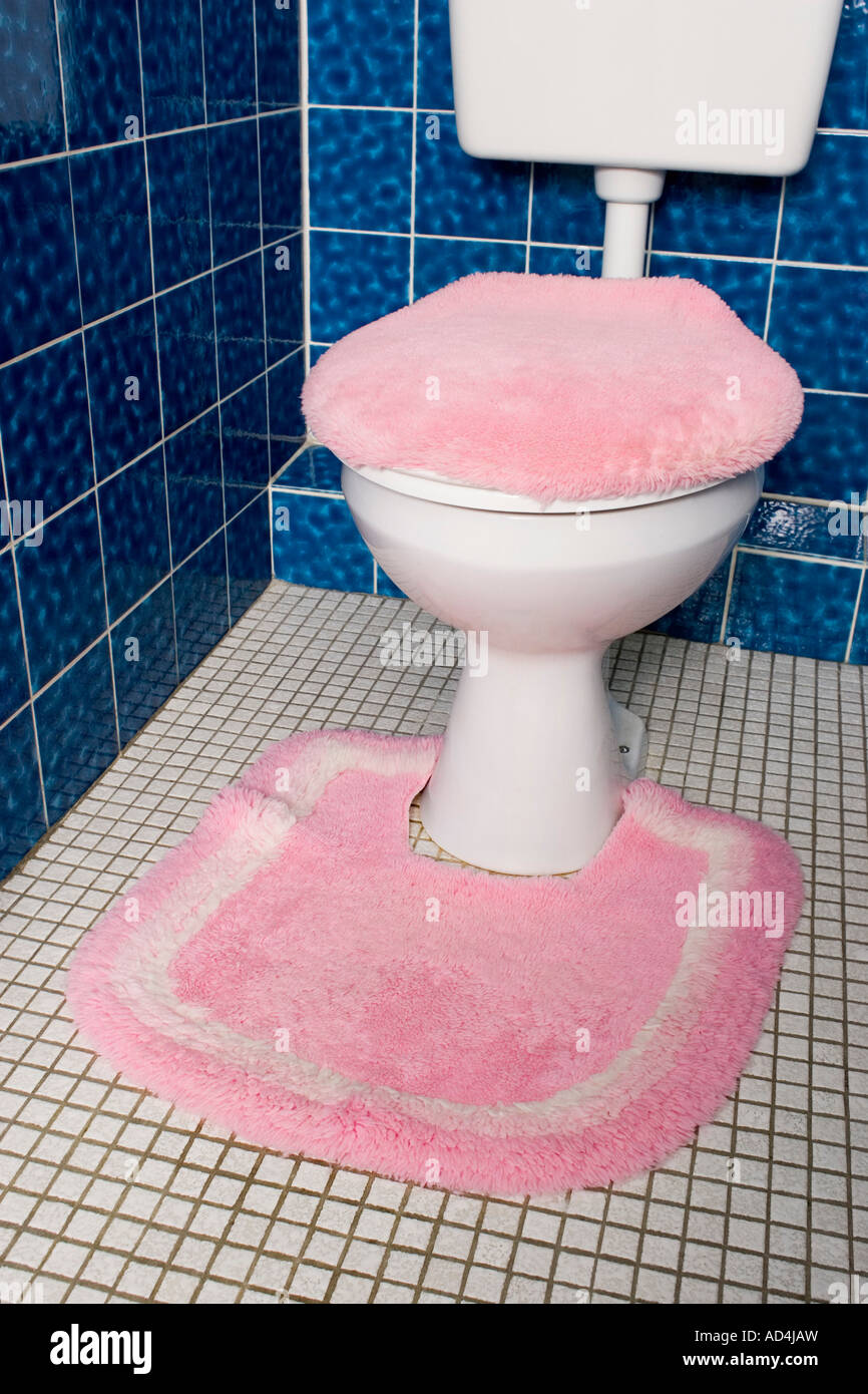 Eine Toilette mit flauschigen rosa Sitzbezug und Teppich ...