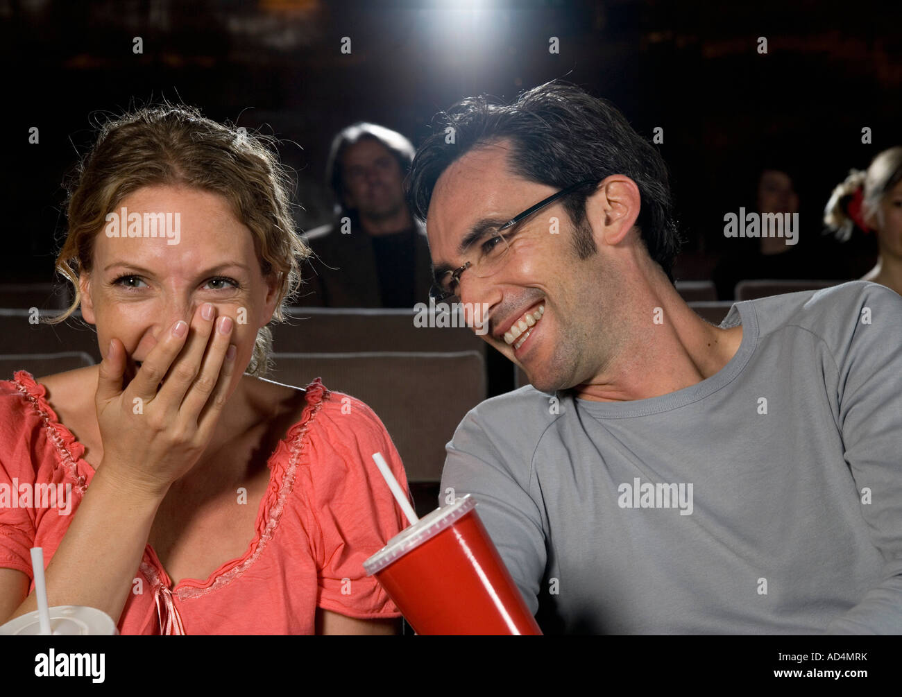 A Mitte erwachsenes paar Lachen in einem Kino Stockfoto