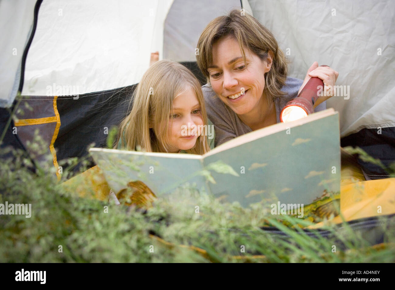 Eine Mutter und Tochter spähte aus einem Zelt und zusammen lesen Stockfoto