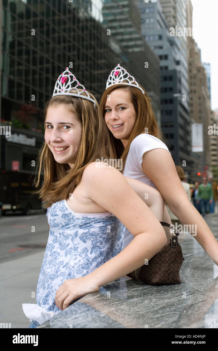 Zwei heranwachsende Mädchen tragen Diademe auf einer Stadtstraße Stockfoto