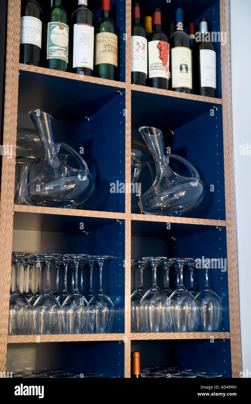 Wein in Flaschen und Gläser in den Regalen Stockfoto