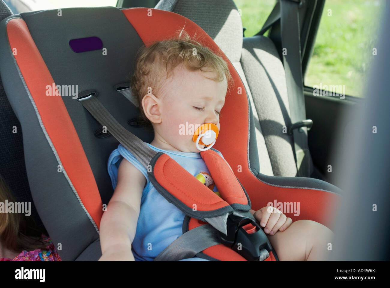 Ein kleiner Junge schläft auf dem Rücksitz eines Autos Stockfoto