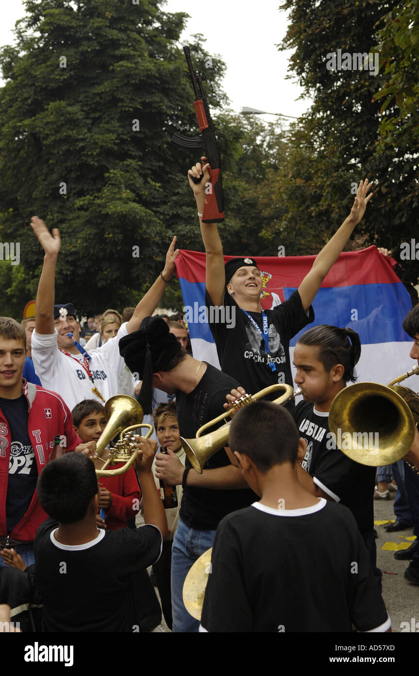 Balkan Brass Bands Musik Festival Guca / Serbien 2005 Männer tanzen vor serbischen Flagge mit Pistole in der Hand Stockfoto