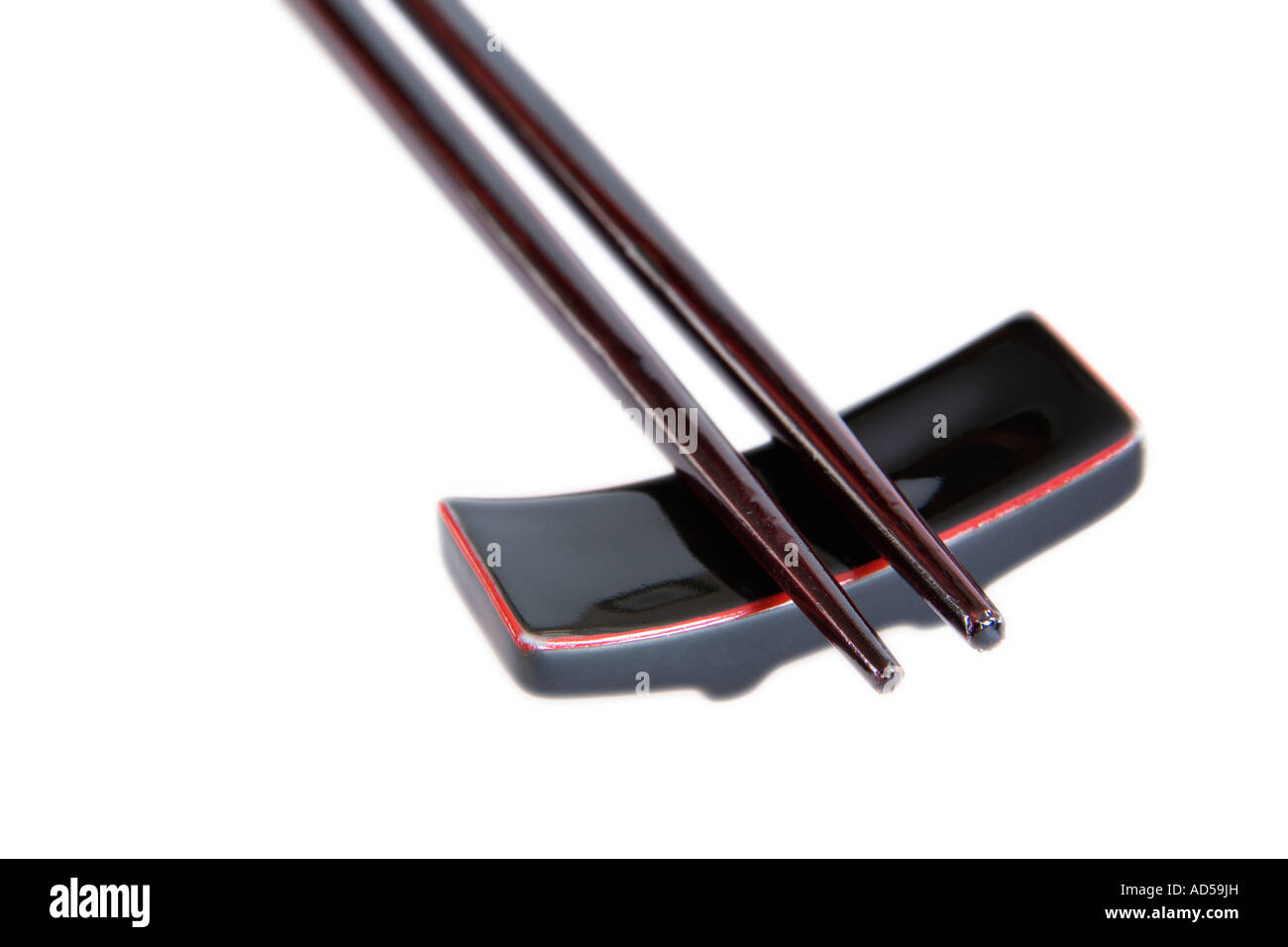 Schwarze japanische chinesische Essstäbchen ruht auf Halter Stockfoto