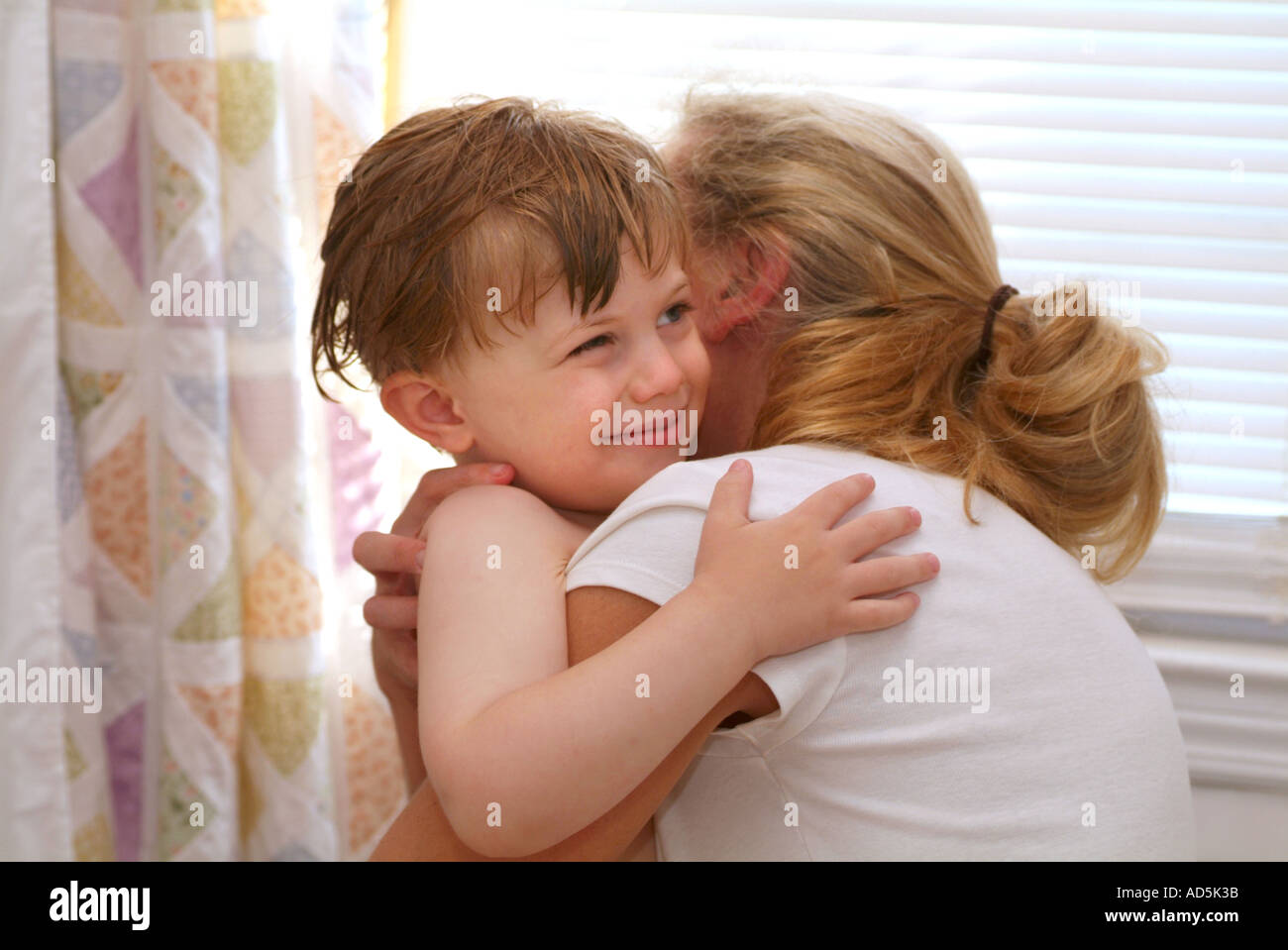 Kleiner Junge seine Mutter umarmt Stockfoto