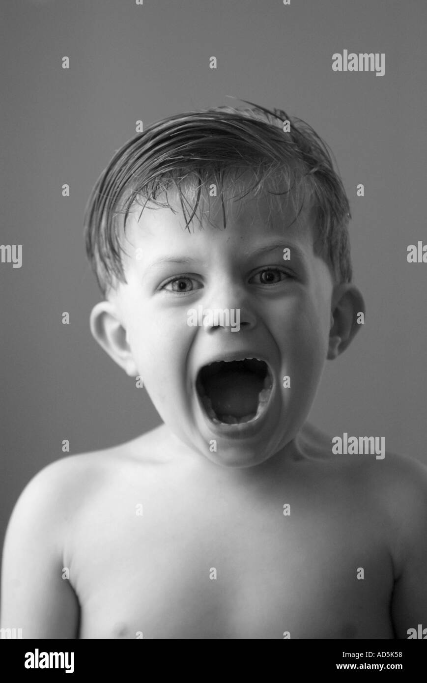 Kleiner Junge mit Mund weit zu öffnen. Schwarz / weiß Stockfoto