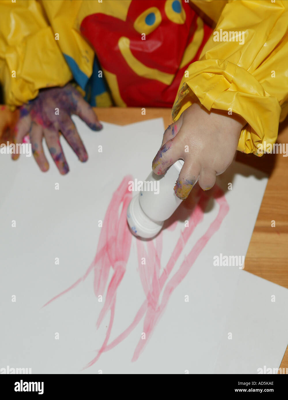 Childs Hände malen mit einem einzigen rosa Malerei Stift auf weißem Papier Stockfoto