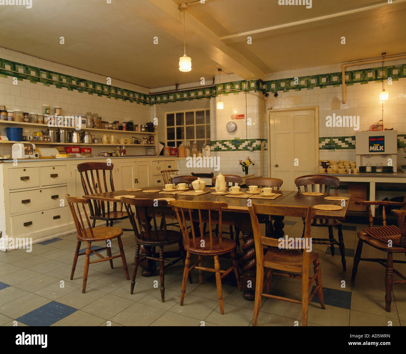 Großer Holztisch und Stühle in alten altmodischen Keller Küche mit weißen  und grünen Fliesenwand Stockfotografie - Alamy