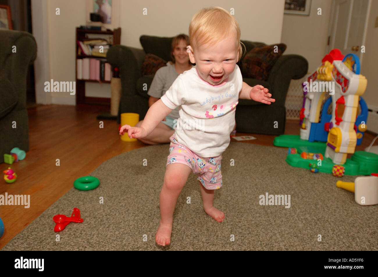 Baby Kleinkind Kind erste Schritte zu Fuß Schritt Lernprojekt 1 ein Jahr alt ein Baby Beine dünne Beine glückliches Baby Schritte Aufregung gehen Stockfoto