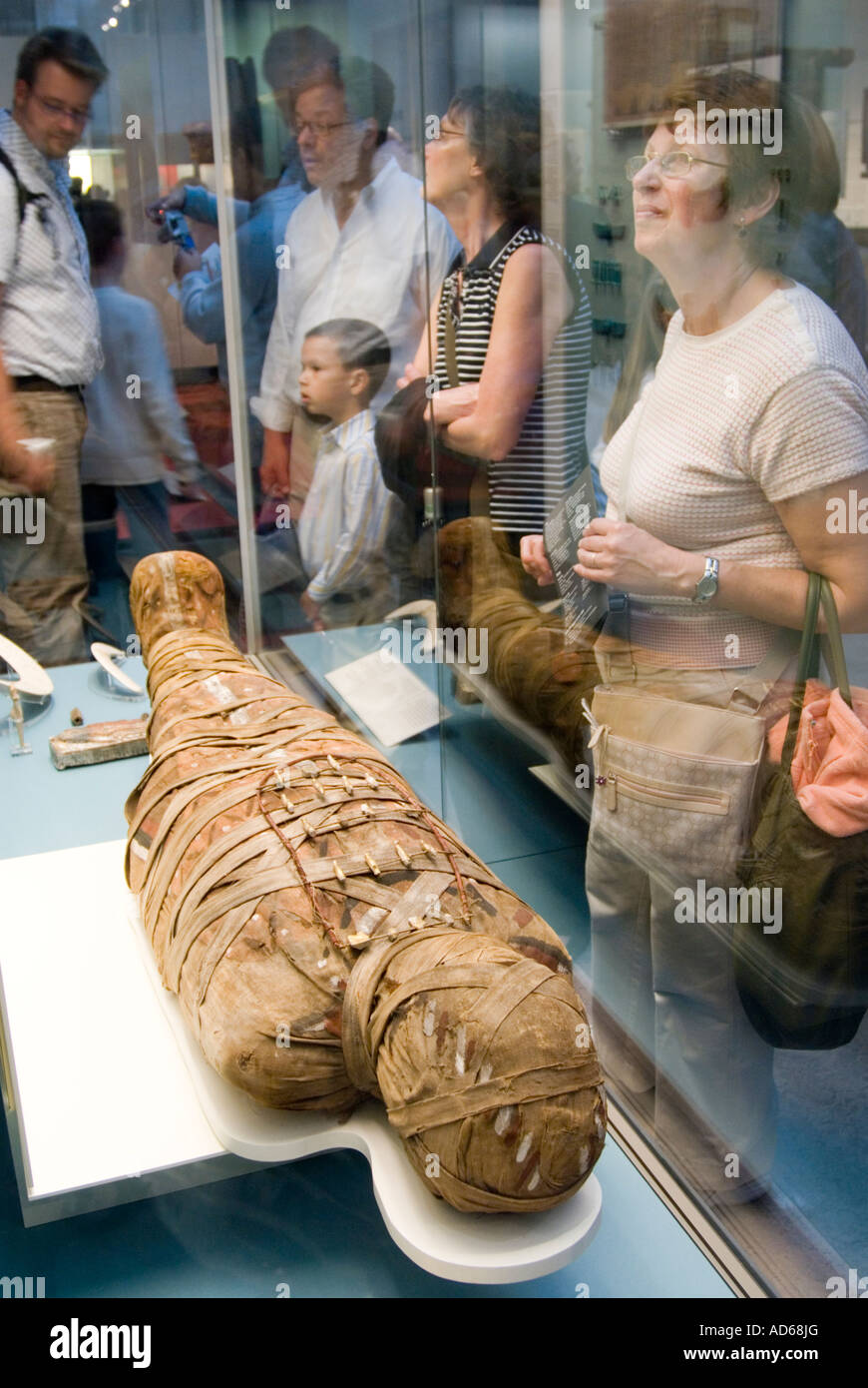 Besucher betrachten einer alten ägyptischen Mumie im British Museum London England UK Stockfoto