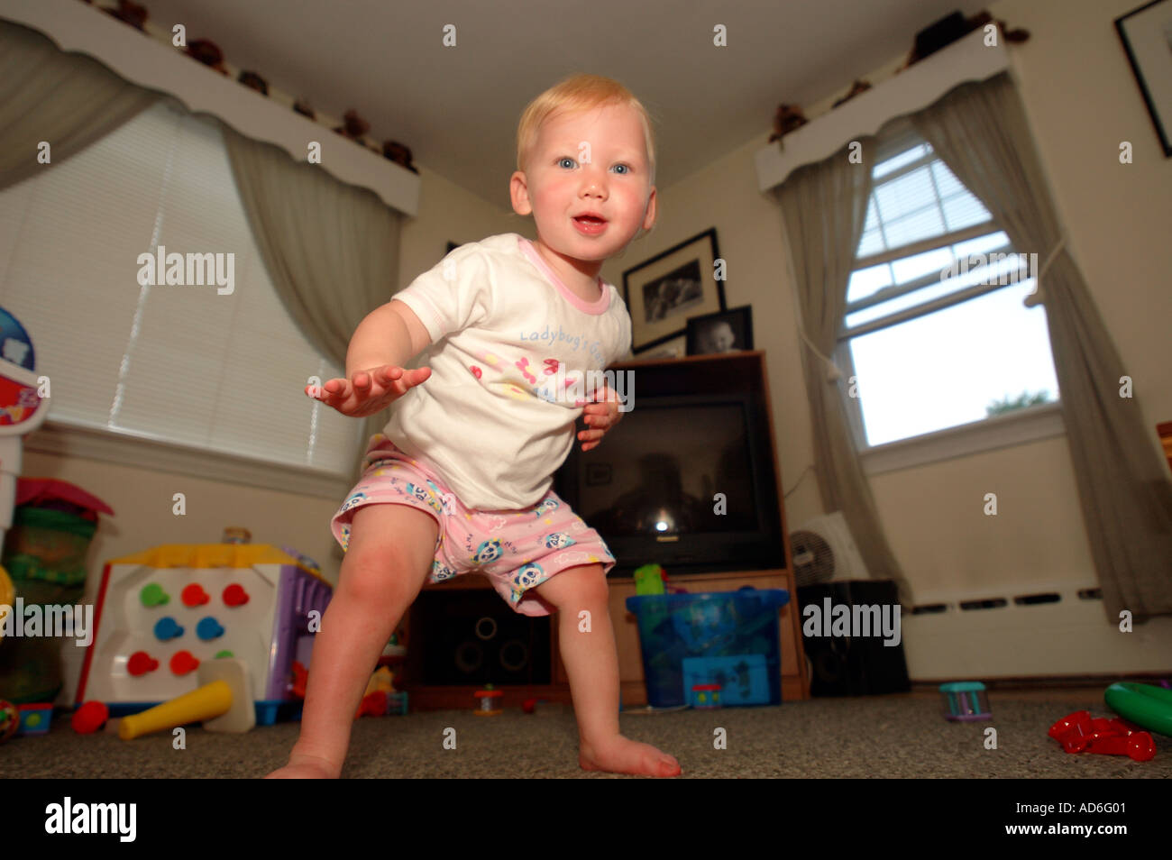 Baby Kleinkind Kind erste Schritte zu Fuß Schritt Lernprojekt 1 ein Jahr alt ein Baby Beine dünne Beine glückliches Baby Schritte Aufregung gehen Stockfoto