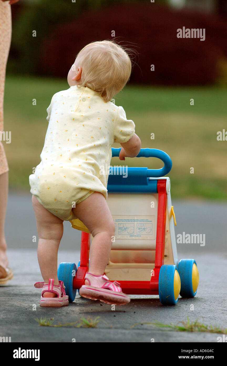 Baby Kleinkind Kind erste Schritte zu Fuß Schritt Lernprojekt 1 ein Jahr alt ein schieben Push Walker Unterstützung zu Fuß Baby Stützfuß zu Fuß Stockfoto