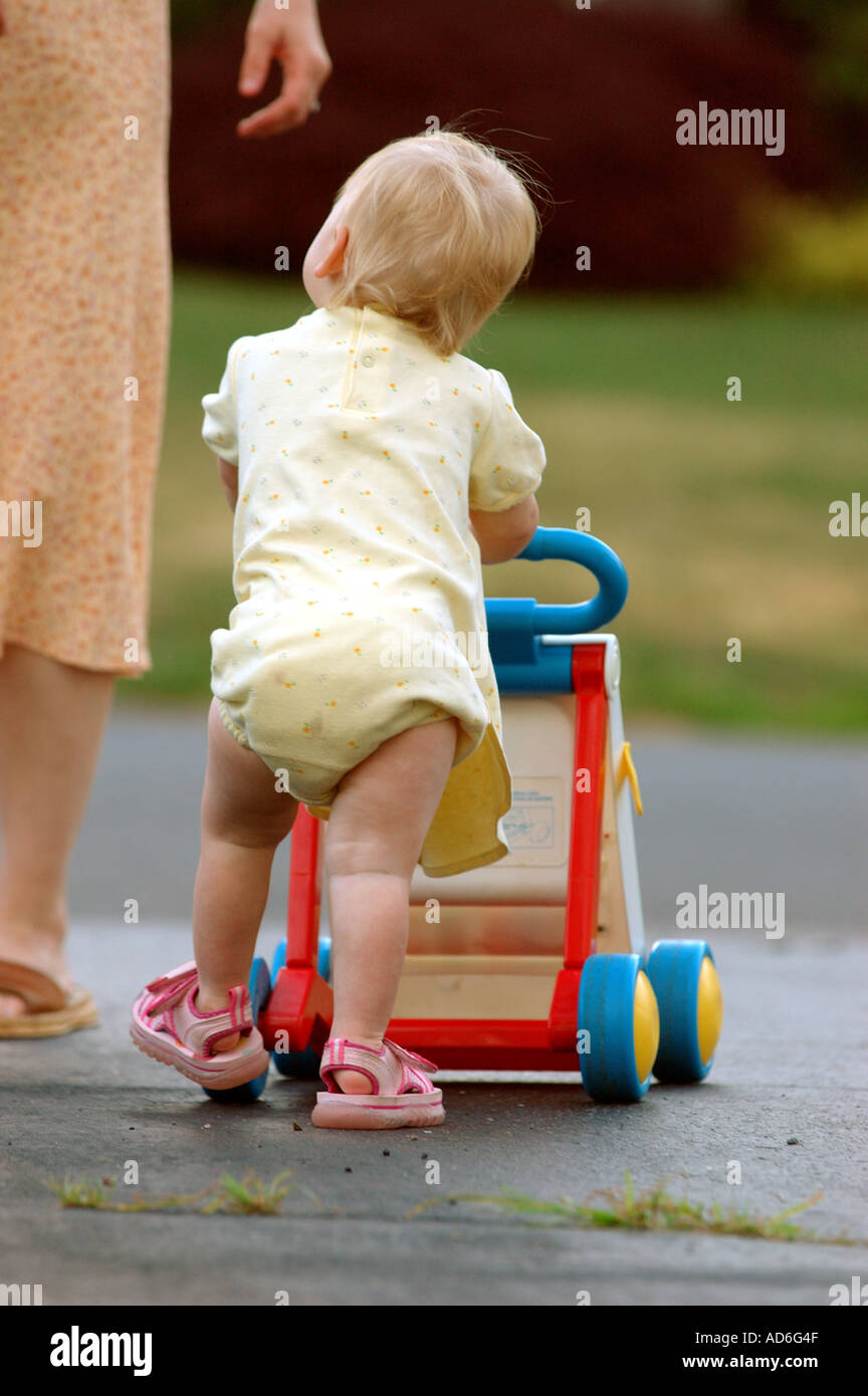 Baby Kleinkind Kind erste Schritte zu Fuß Schritt Lernprojekt 1 ein Jahr alt ein schieben Push Walker Unterstützung zu Fuß Baby Stützfuß zu Fuß Stockfoto