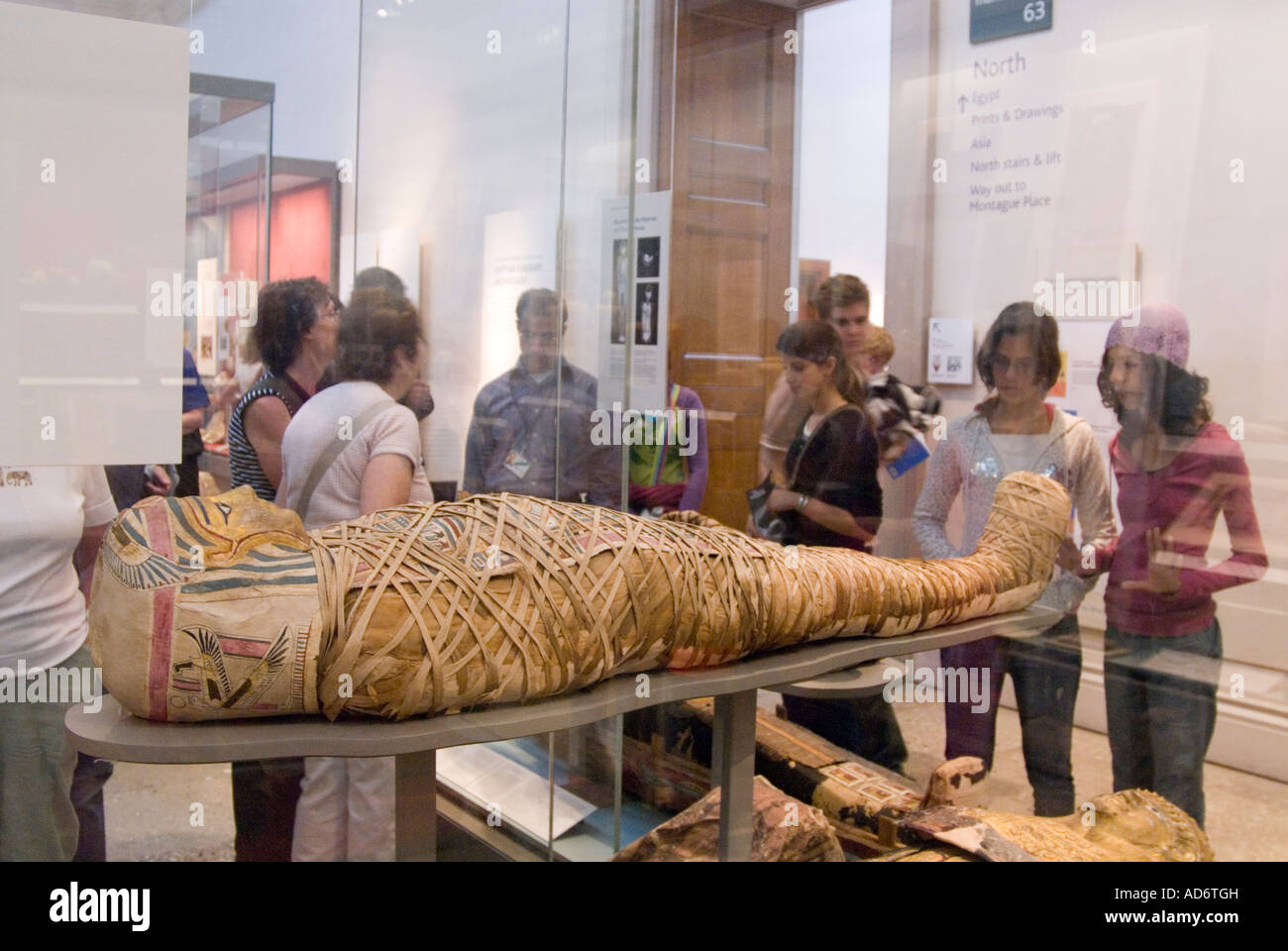 Besucher betrachten einer alten ägyptischen Mumie im British Museum London England UK Stockfoto