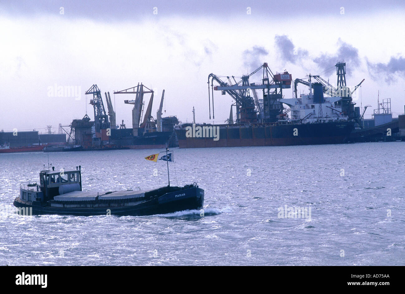 NIEDERLANDE ROTTERDAM HAFEN INDUSTRIELANDSCHAFT UND BARGE IM VORDERGRUND Stockfoto