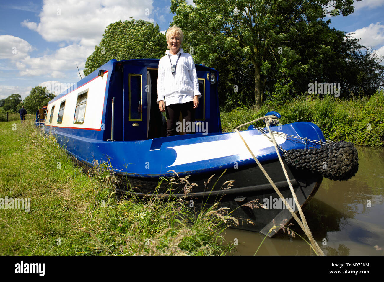 Mittlere gealterte Dame Bootsfahrer auf ihre Narrowboat auf dem North Oxford Kanal, Warwickshire Stockfoto