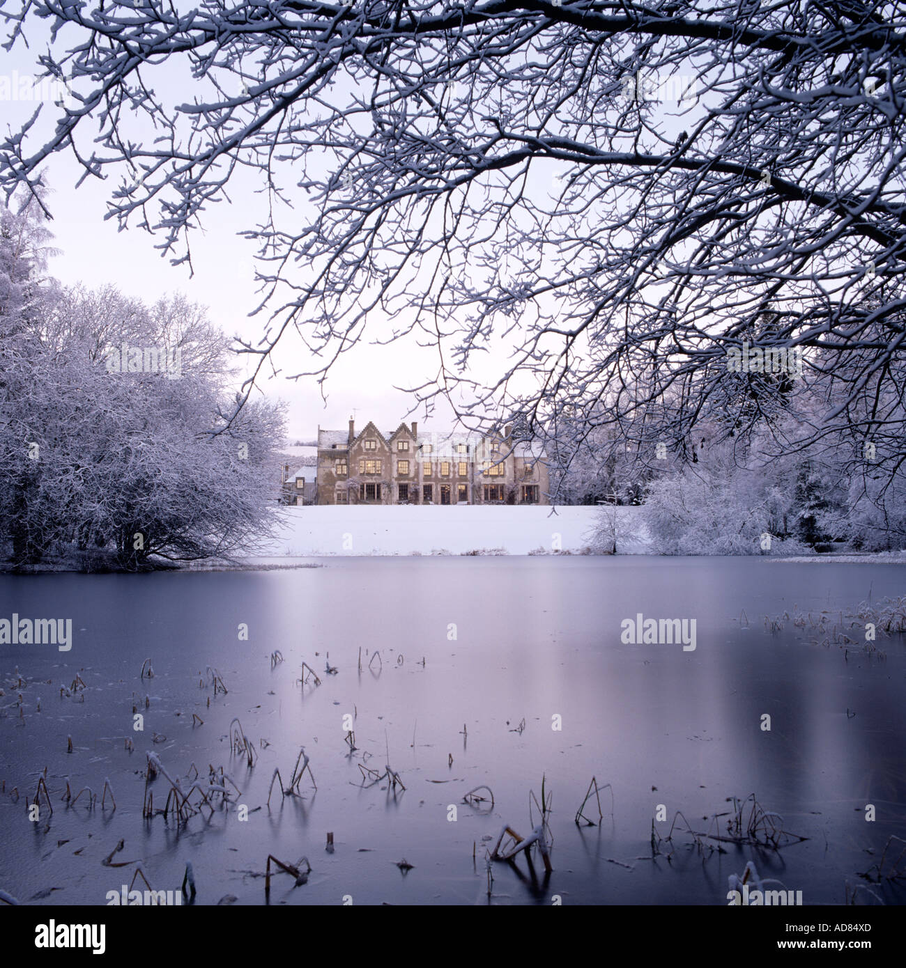 Außen Höhe des schottischen Estate Herrenhaus im Schnee auf der gegenüberliegenden Seite des Sees Stockfoto