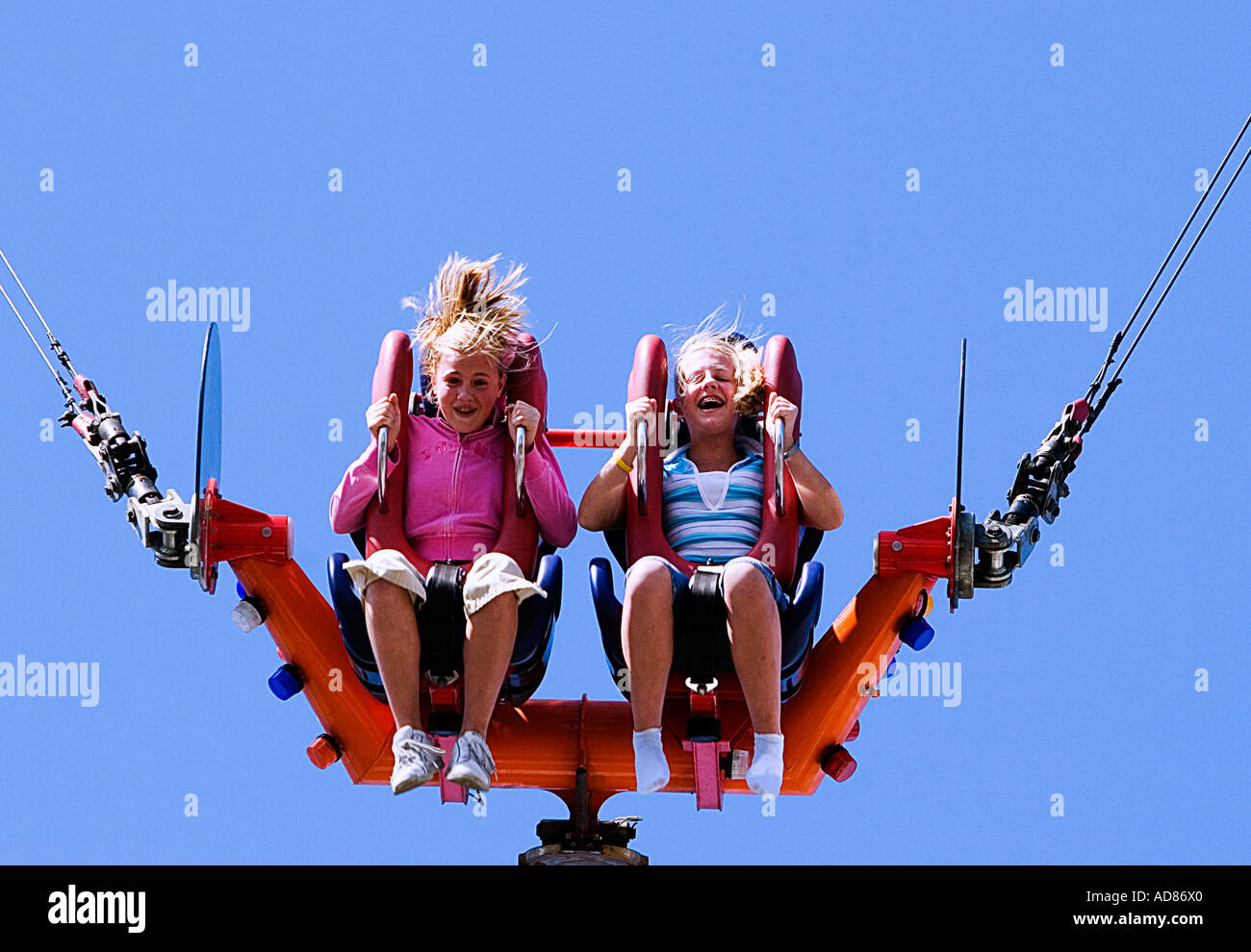 Foto von zwei kleinen Mädchen in Mitte hüpfen auf der Sling Shot-Karneval-Fahrt Stockfoto