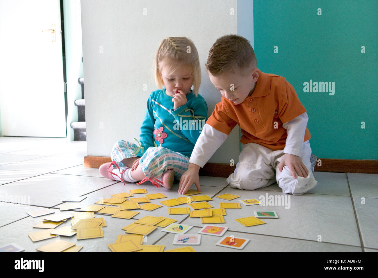 Bruder und Schwester sind mit Karten spielen. Stockfoto