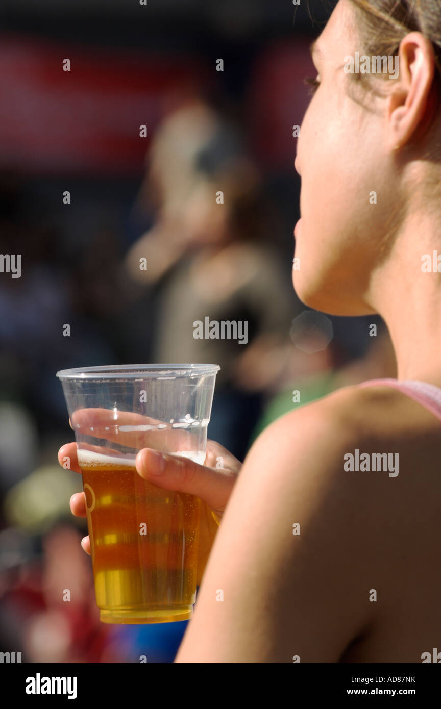Seitenprofil junge Frau mit Kunststoff-Glas Bier Stockfoto