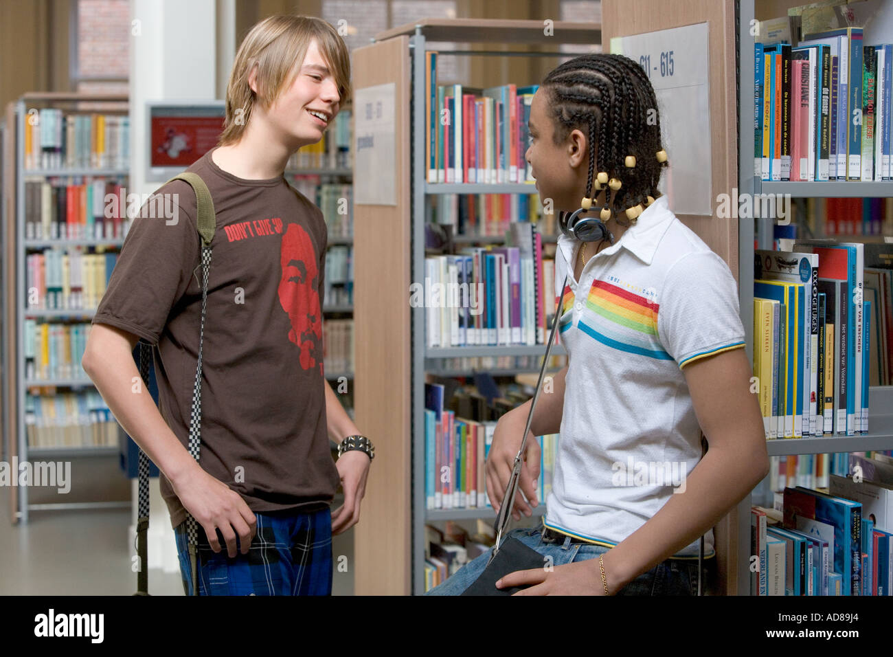 Zwei Jungs im Teenageralter reden in der Bibliothek Stockfoto