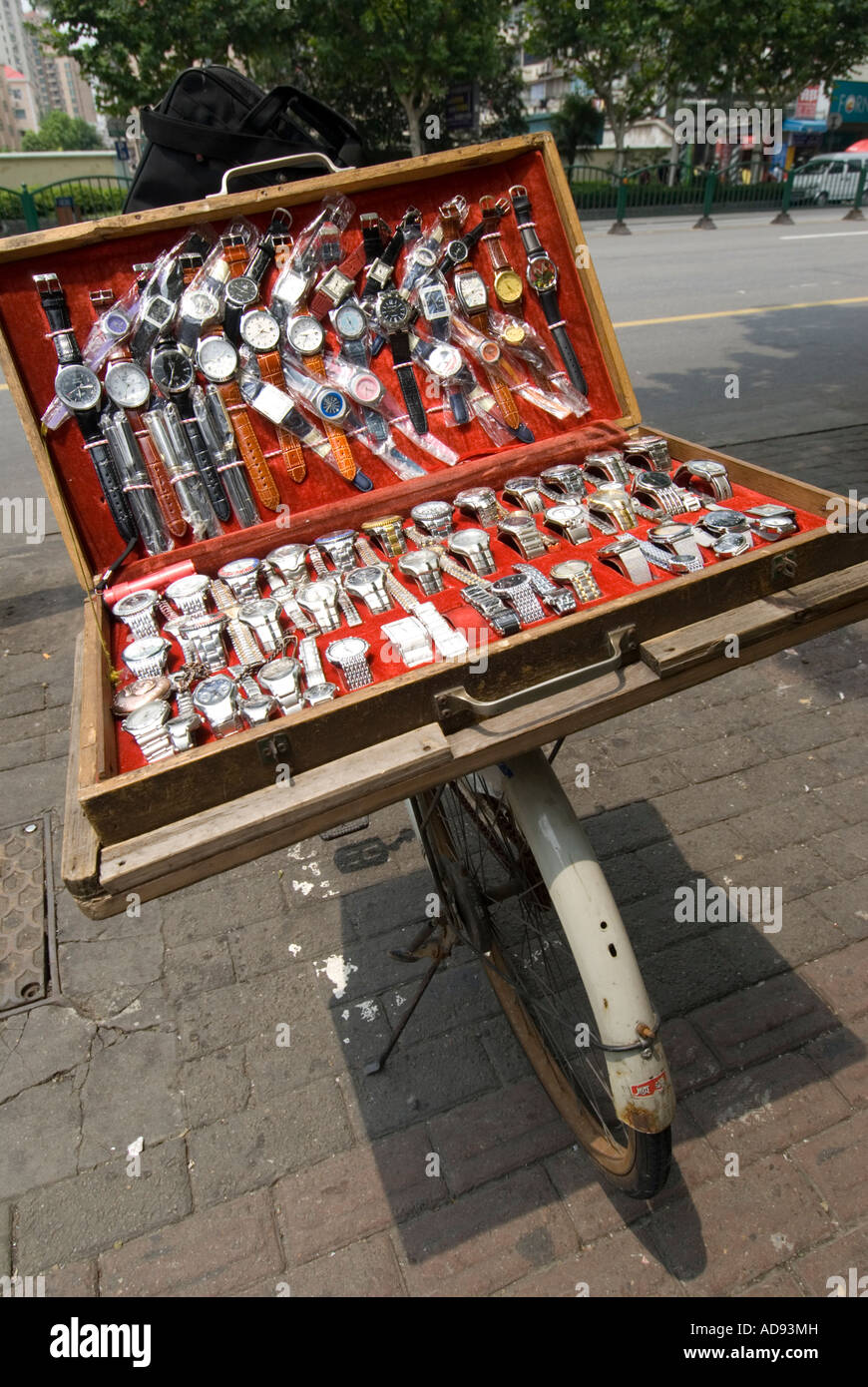 Gefälschte Uhren zum Verkauf von Fall auf dem Fahrrad auf der Straße in Shanghai 2007 Stockfoto