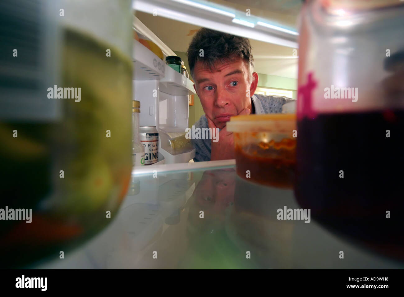 Mann auf der Suche nach Essen im Kühlschrank Stockfoto