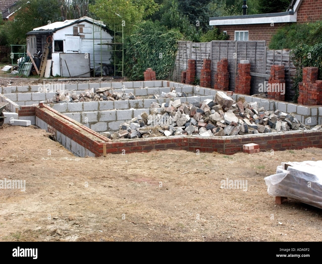 Grundstück und ein neues freistehendes Haus Grundlagen abgeschlossen und Haufen von hardcore für Beton, Mauerwerk & blockwork an DPC Ebene nivelliert werden. Stockfoto