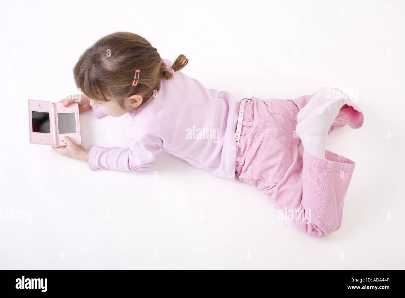 Mädchen in Rosa Kleidung mit einem rosa Gameboy Stockfoto