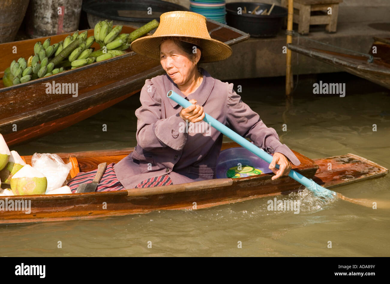 Frau in einem hölzernen Kanu am schwimmenden Markt Damnoen Saduak in der Nähe von Bangkok-Ratchaburi, Thailand Stockfoto