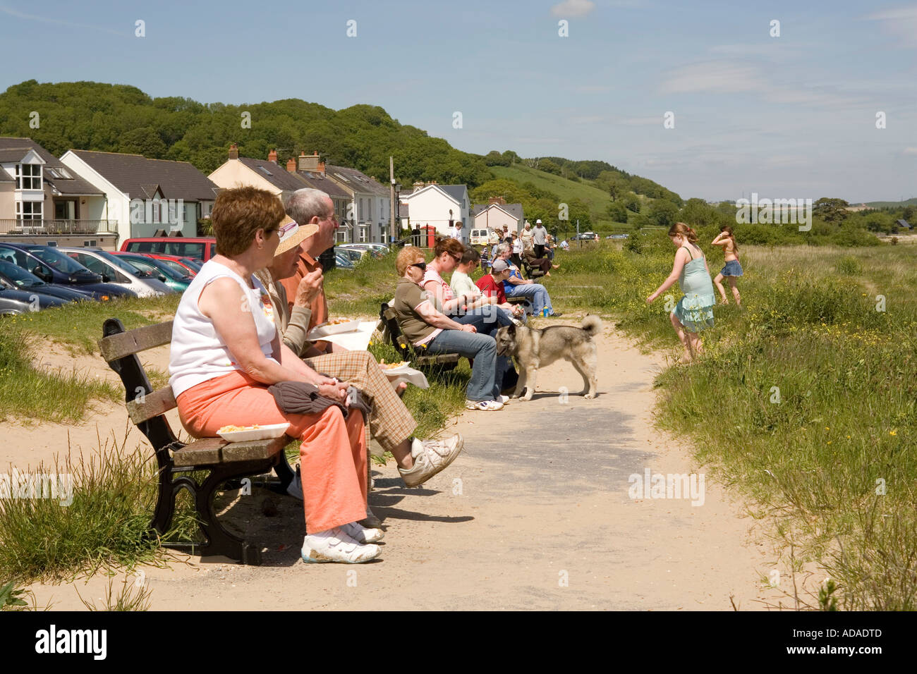 Wales Carmarthenshire Carmarthen Llanstephan Leute auf den Bänken am Meer Stockfoto