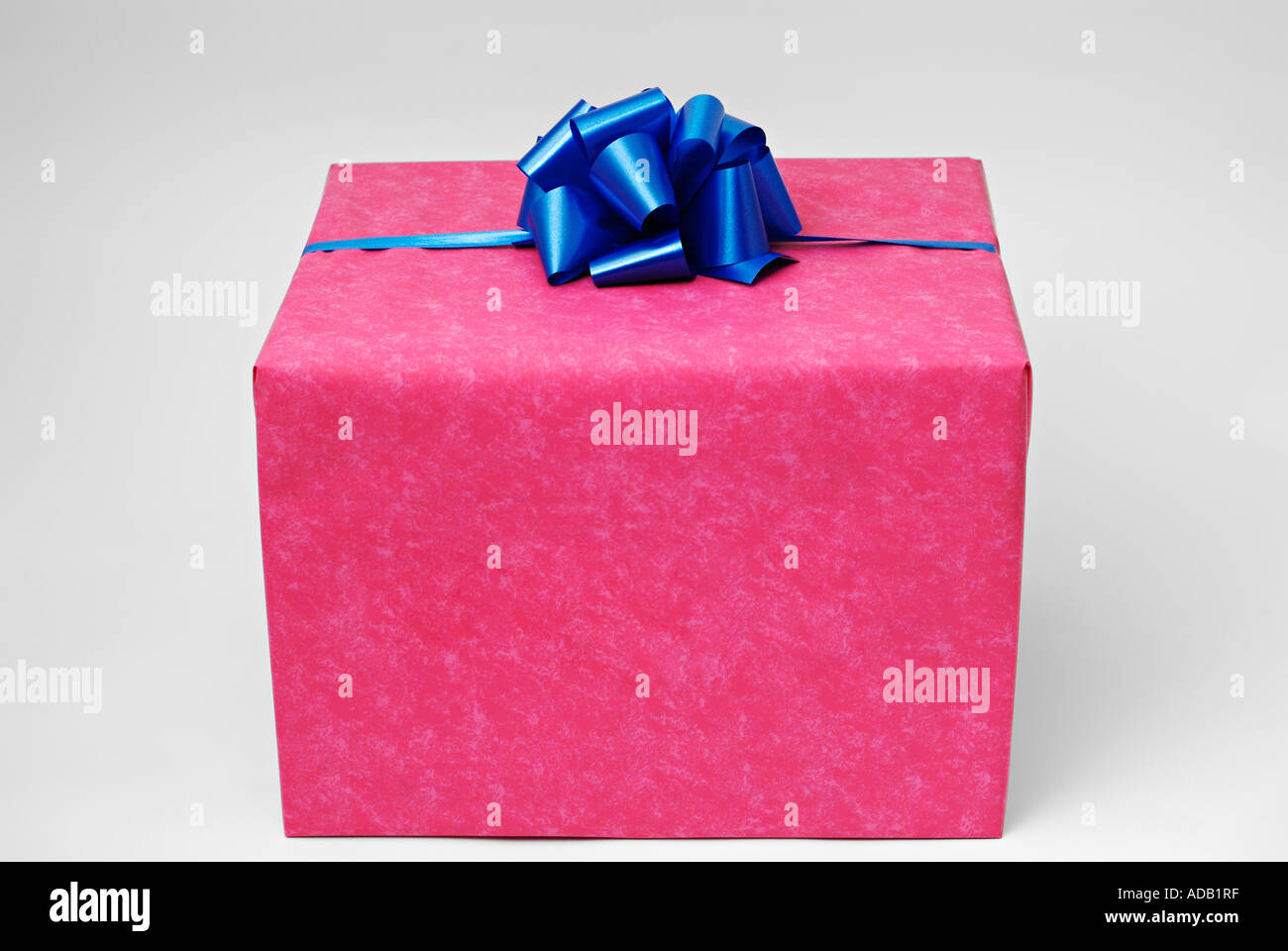Geschenk verpackt mit rotem Papier und ein blaues Band Stockfoto