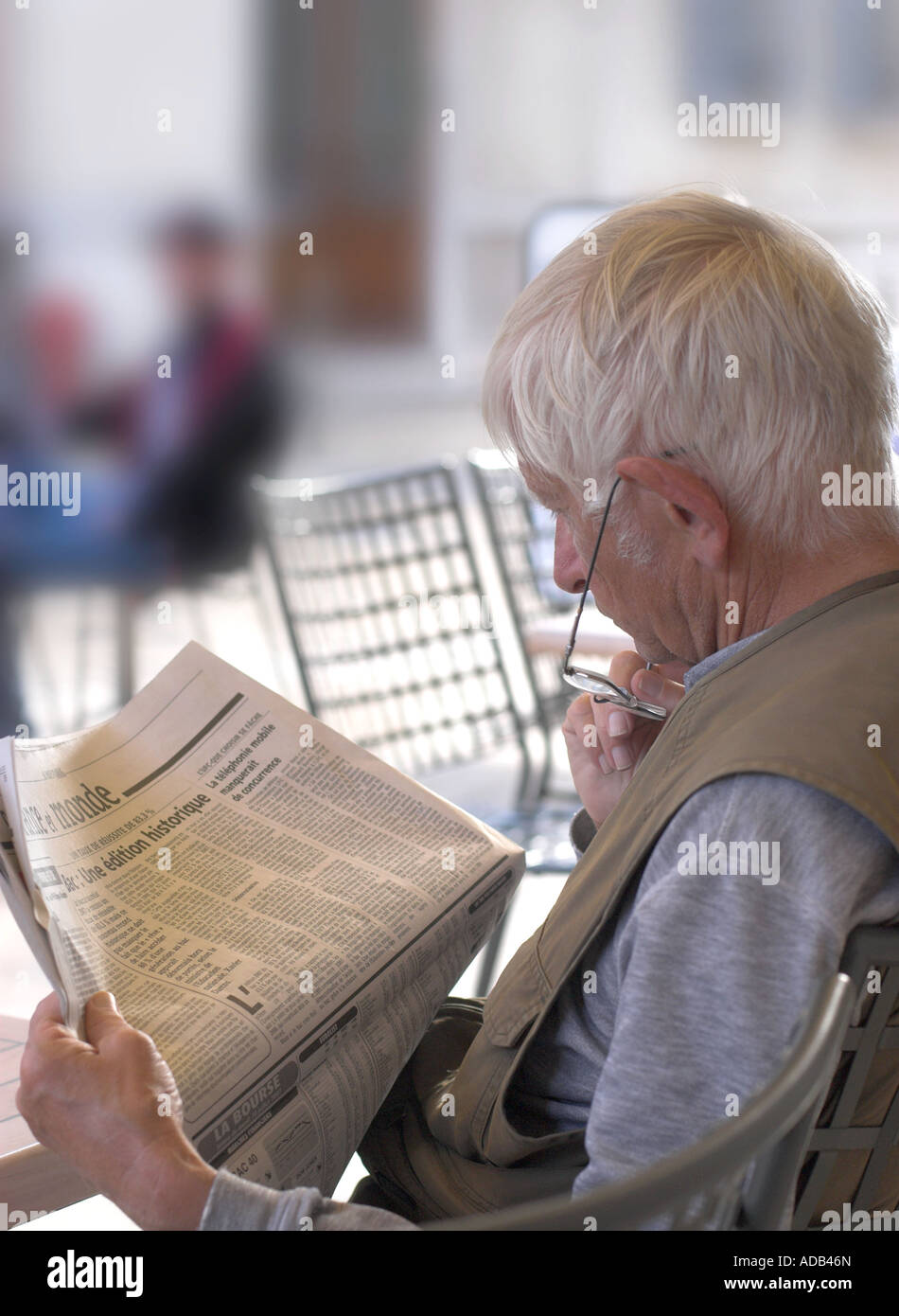 Mann liest Zeitung außerhalb Café in Beaune, Frankreich. Stockfoto