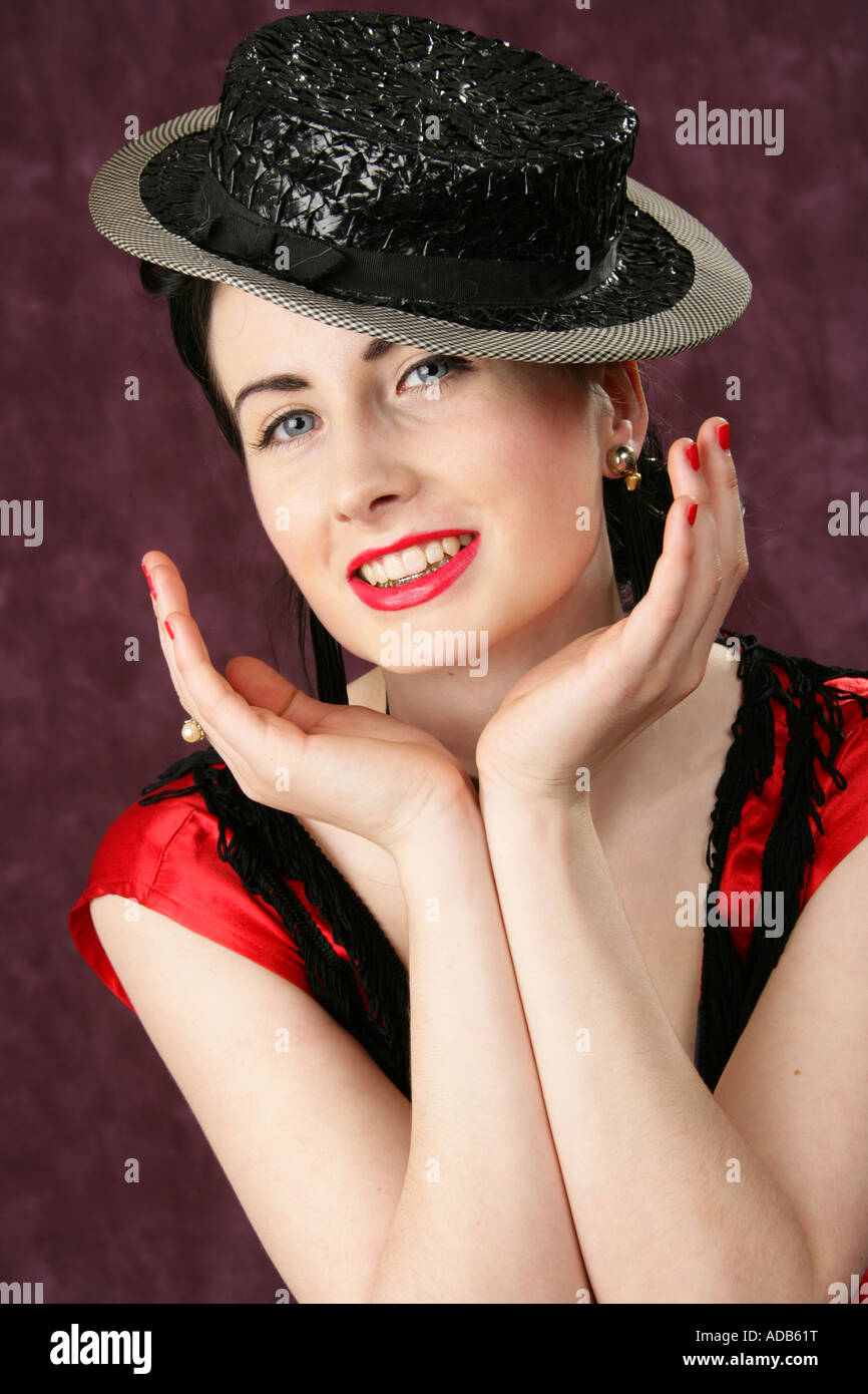 Ein Lächeln auf den Lippen Pin Up Girl in einem schwarzen Hut und roten Kleid Stockfoto