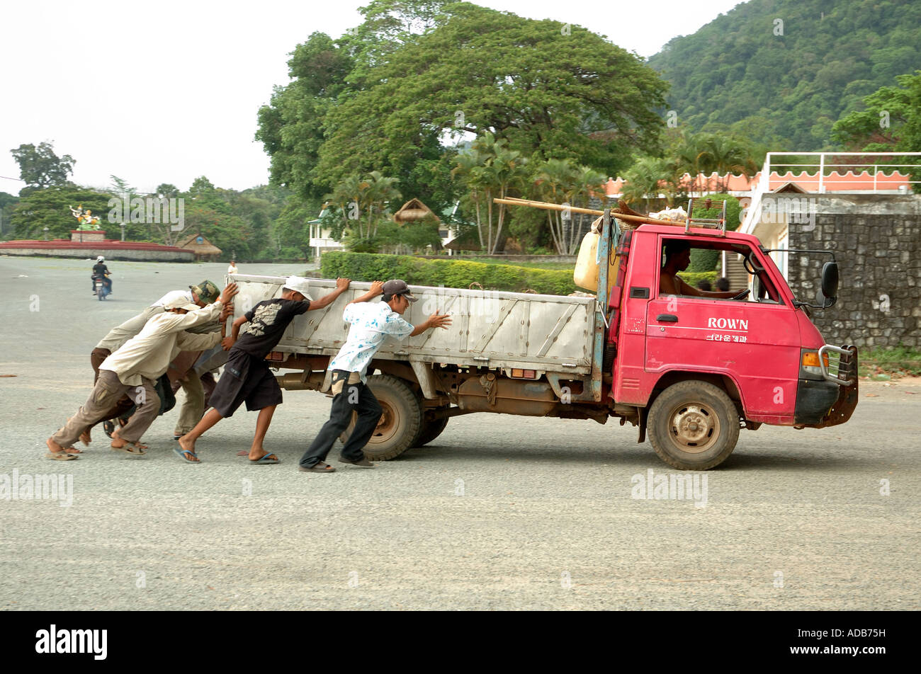 Männer, die eine gebrochene herunterdrücken LKW in Kep, Kambodscha Stockfoto