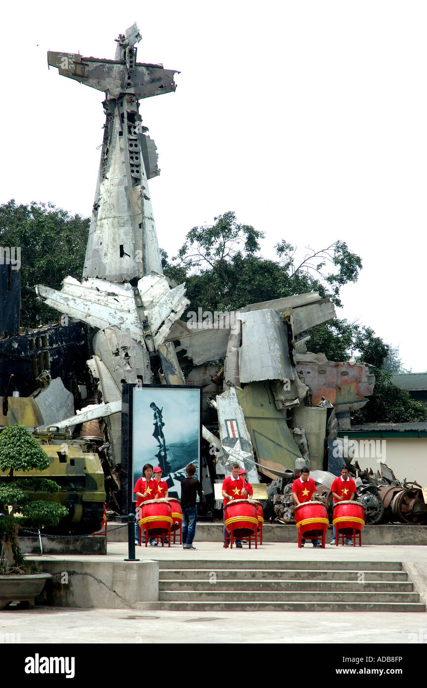 Ein zerstörter B52-Bomber in Hanoi, Vietnam, und Menschen spielt Bongo-Trommeln Stockfoto