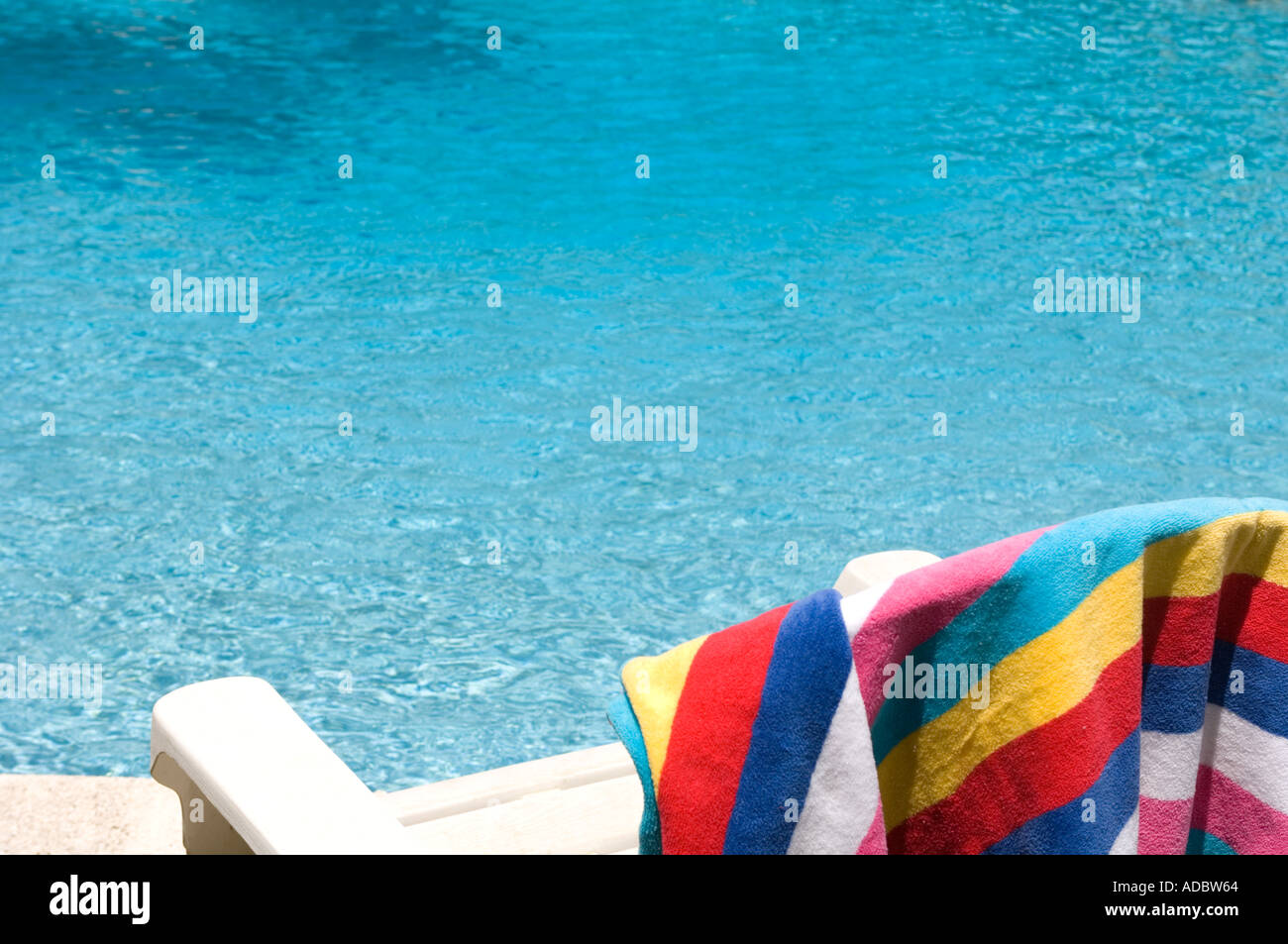 bunten Strandtuch drapiert über Lounge Swimmingpool Stockfoto