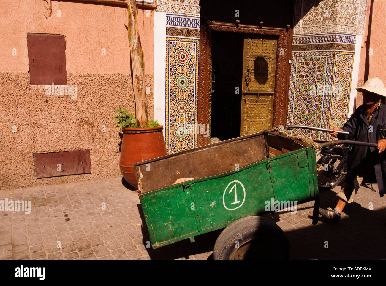 marokkanischen Mann schob einen leeren Wagen in den Straßen der Altstadt, der Medina, Marrakesch, Marokko Stockfoto