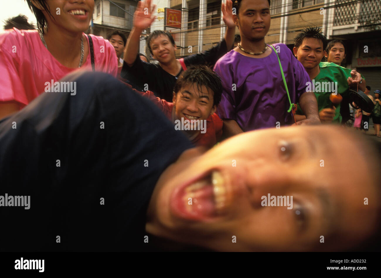 Glückliche junge Männer, die Teilnahme an den Prozessionen am Songkran Thai Neujahr in Chiang Mai Thailand Stockfoto