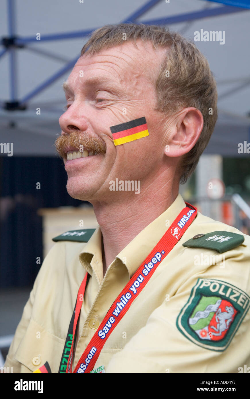 Ein deutscher Polizist trägt einen Aufkleber mit den deutschen Nationalfarben in seinem Gesicht Stockfoto