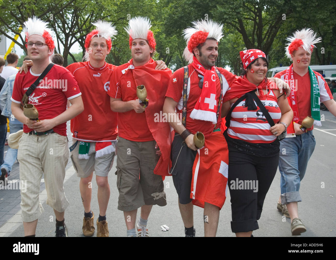 Schweizer Fußball-Fans, die markante Kuhglocken in gute Laune vor dem WM-Stadion Dortmund Stockfoto