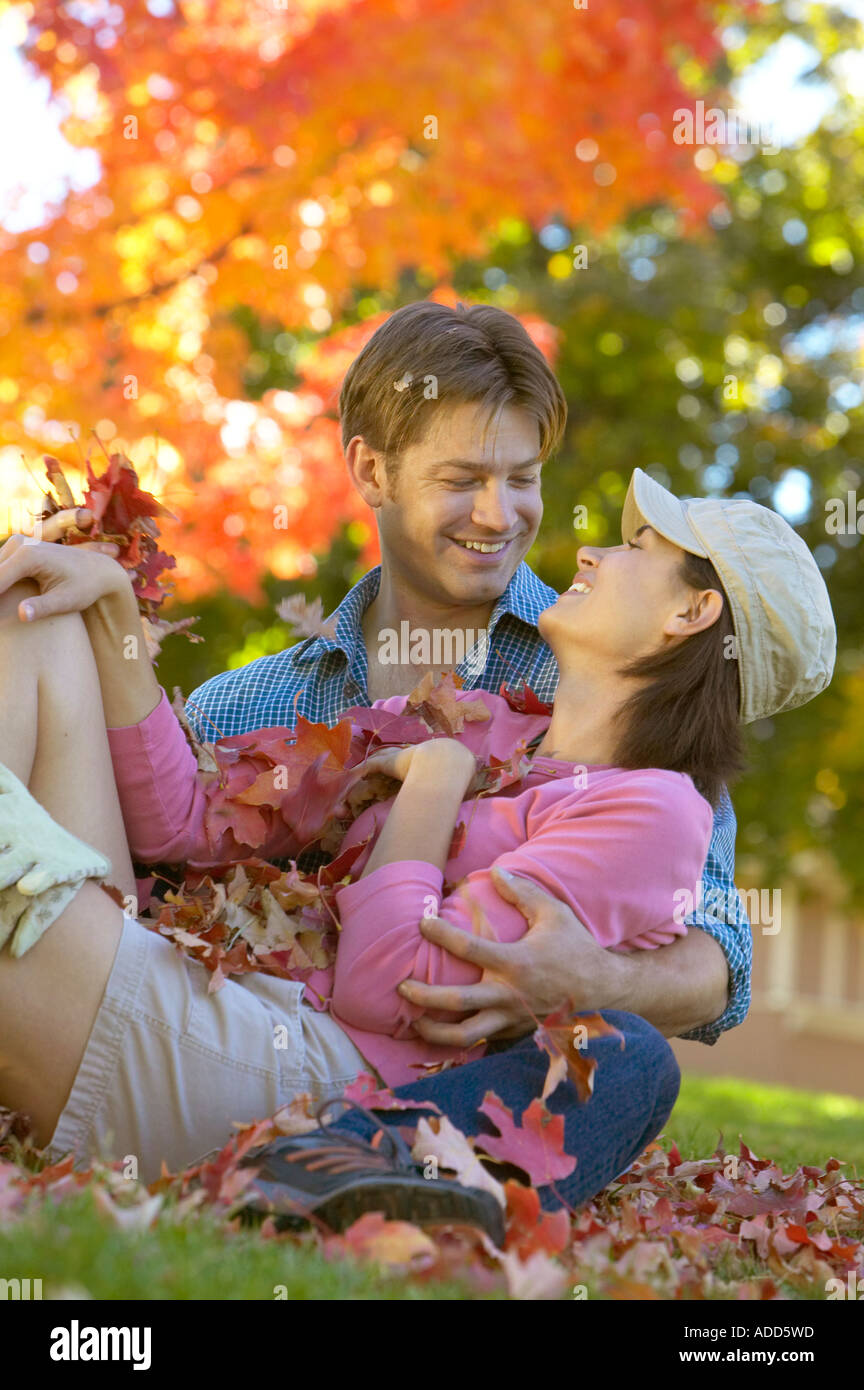 glücklich Anfang 30 kaukasische paar spielen im Herbst Blätter Stockfoto